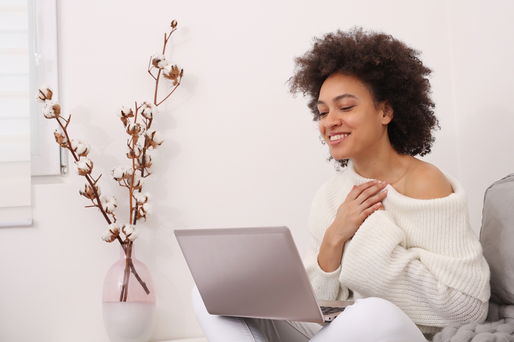 A woman at Her House Smiling at Her Computer